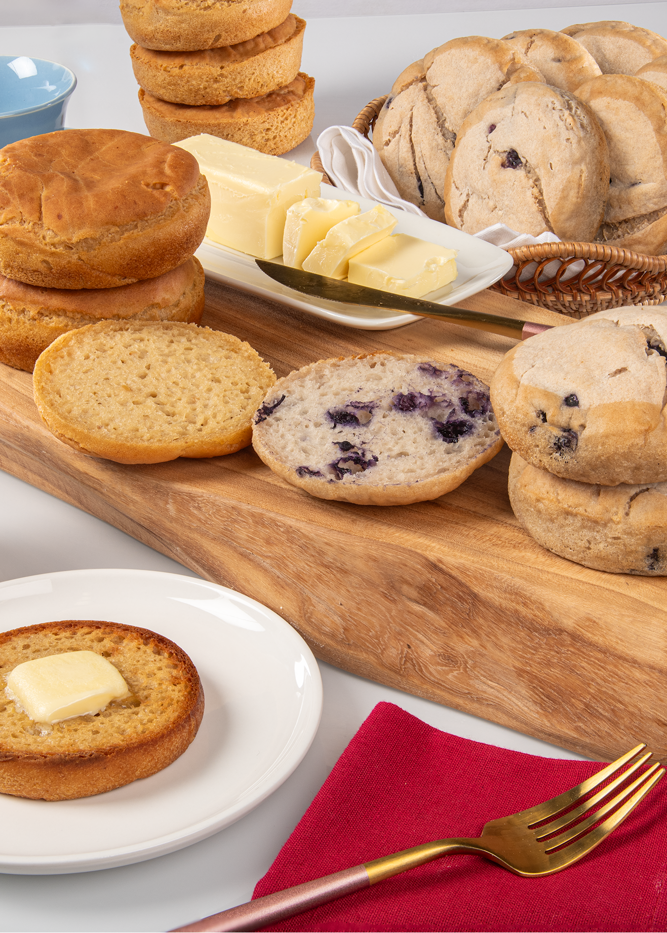 Assorted english muiffins on a wooden board with a white background
