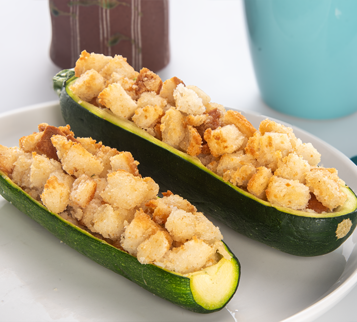 Plain stuffing cubes in sliced zucchini, crumb topping filling the green boats