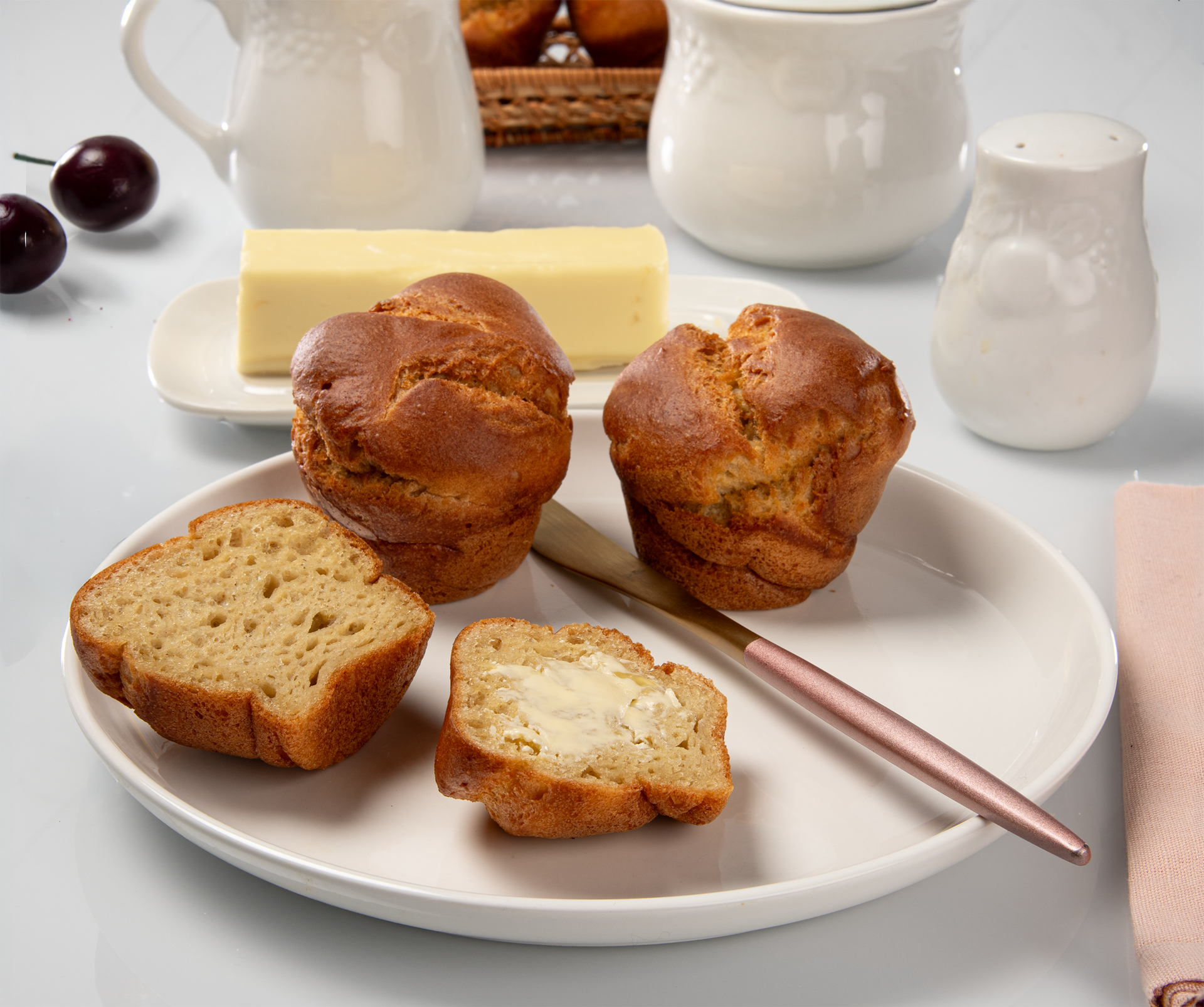 Oat rolls on a plate with sliced pieces and butter knife