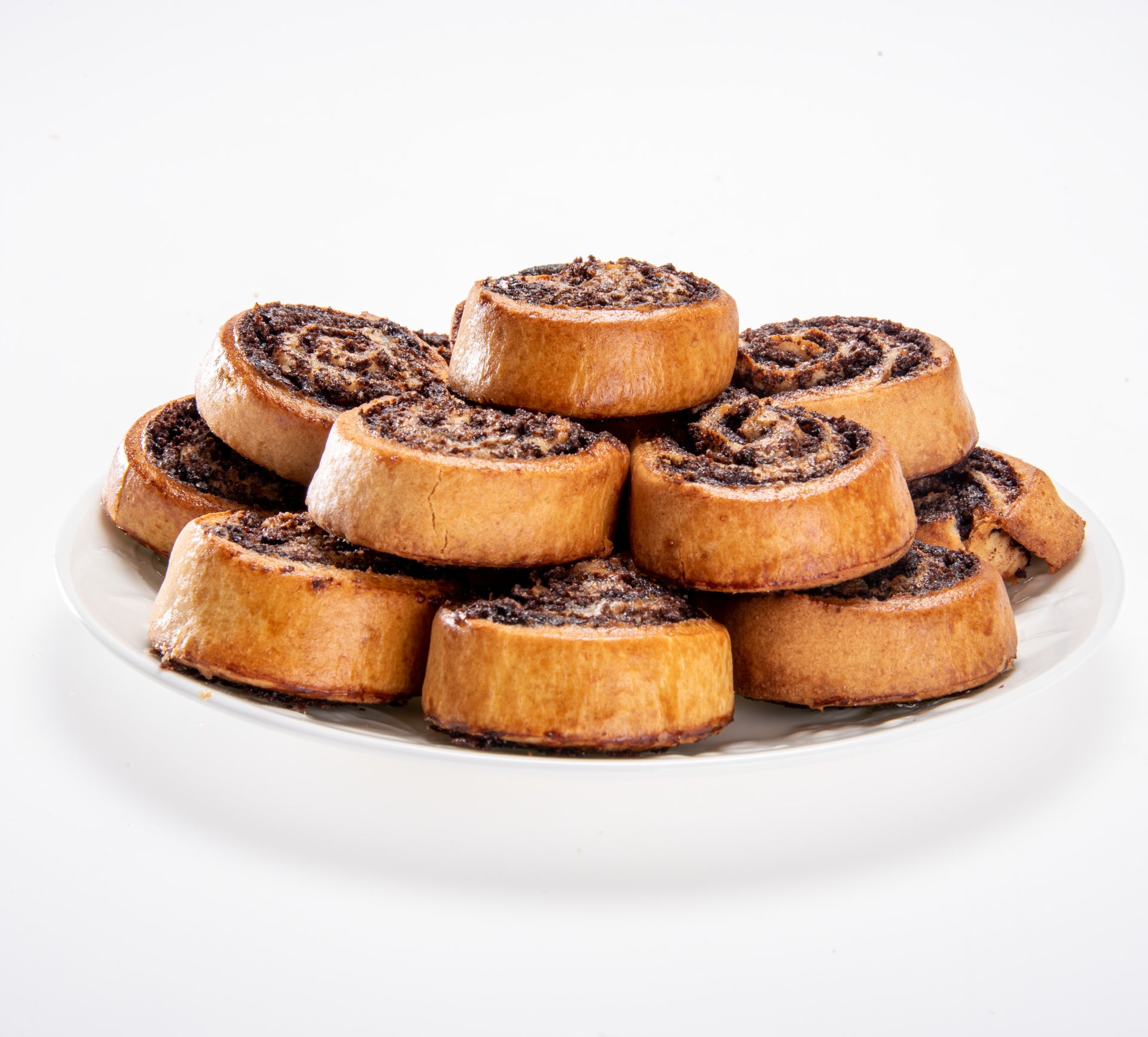 Chocolate rugelach cookies on a serving plate, assorted ring-shaped pastries