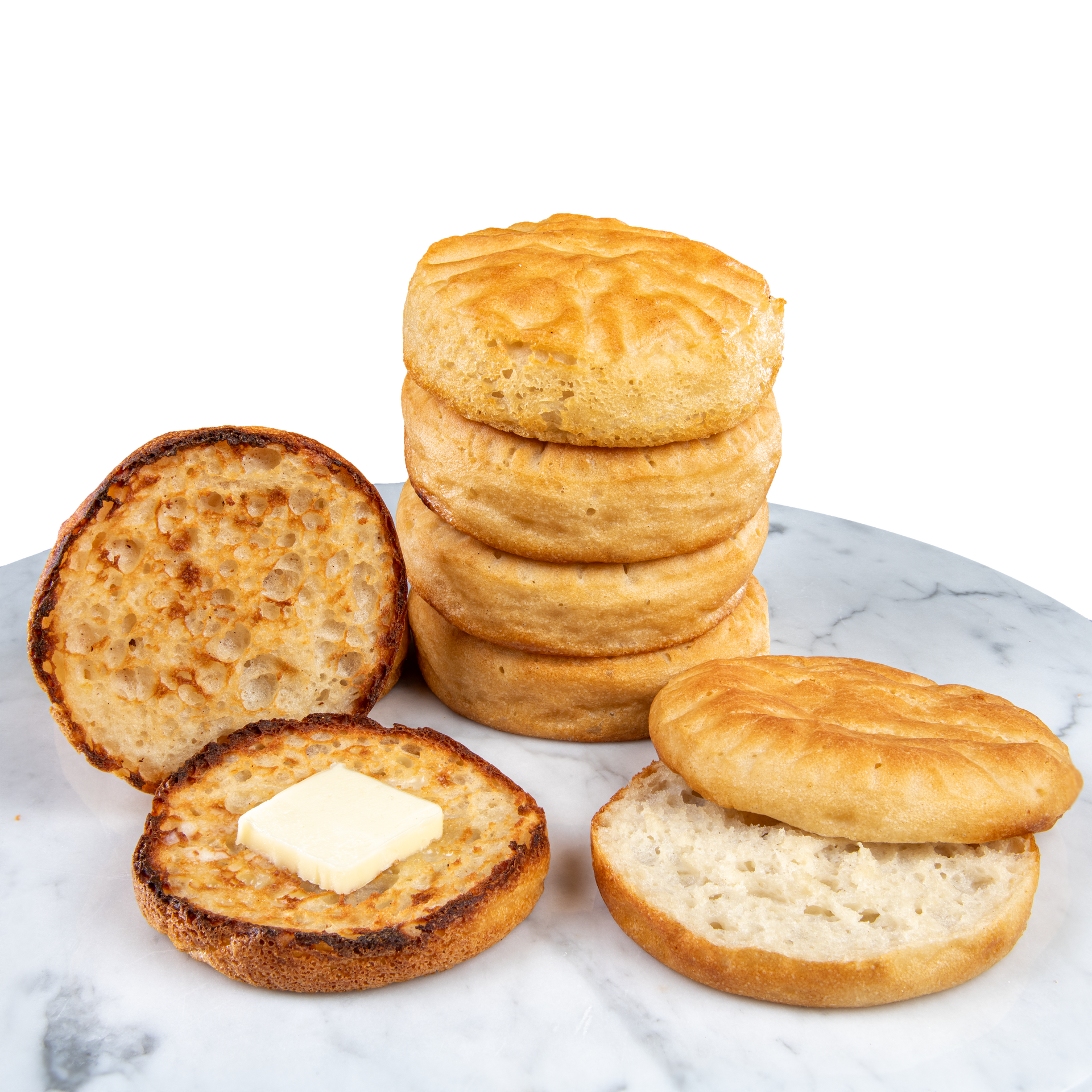 Stack of English muffins with sliced halves and butter