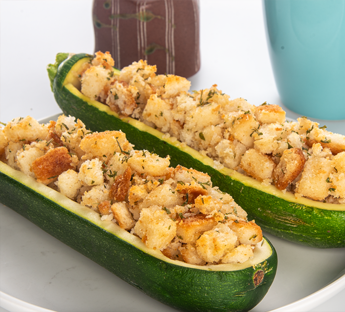 Herb seasoned stuffing in zucchini boats, golden crumb topping with herbs